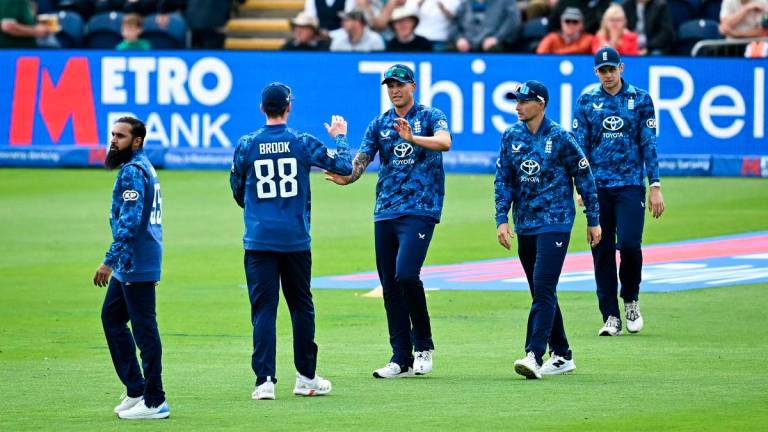 England’s Harry Brook (2nd) congratulates England’s Brydon Carse (C) after taking the wicket of West Indies’ Brandon King (unseen) during the second One Day International (ODI) cricket match between England and West Indies at Sophia Gardens cricket ground in Cardiff on June 1, 2025. (Photo by Paul ELLIS / AFP)