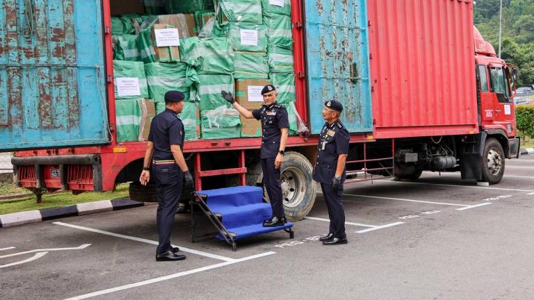 Selangor Police Chief, Datuk Shazeli Kahar (second from right), showing the container carrying untaxed cigarettes that was successfully seized, during a press conference on the arrest and seizure of untaxed cigarettes at the Sepang District Police Headquarters today. - BERNAMA