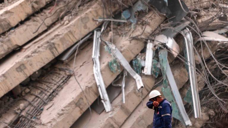A rescue worker wipes his face with his elbow at the site of an under-construction building collapse in Bangkok on April 2, 2025, five days after an earthquake struck central Myanmar and Thailand. (Photo by Chanakarn Laosarakham / AFP)