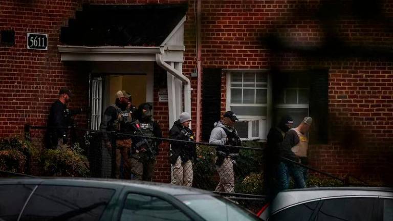 Officers from U.S. Immigration and Customs Enforcement, the Bureau of Alcohol, Tobacco, Firearms and Explosives and the Drug Enforcement Administration leave after unsuccessfully attempting to gain entry into an apartment in pursuit of a Honduran man near Rockville, Maryland - REUTERSpix