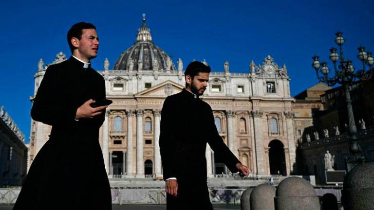 Priests walk past St Peter’s Basilica in the background, following the funeral of the Pope and ahead of the conclave, at St Peter’s Square in The Vatican, on May 2, 2025. AFPpix