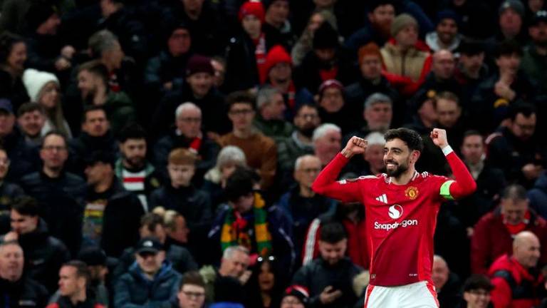 Manchester United's Portuguese midfielder #08 Bruno Fernandes celebrates scoring the team's second goal from the penalty spot during the UEFA Europa League Last 16 Second Leg football match between Manchester United and Real Sociedad at Old Trafford stadium in Manchester, north west England, on March 13, 2025.- AFPPIX