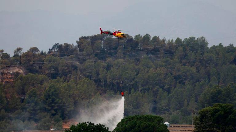 A helicopter helps to extinguish an ongoing wildfire in Xerta, which is one of the confined villages in the Tarrragona province in Catalonia, Spain, July 8, 2025. REUTERS/Nacho Doce