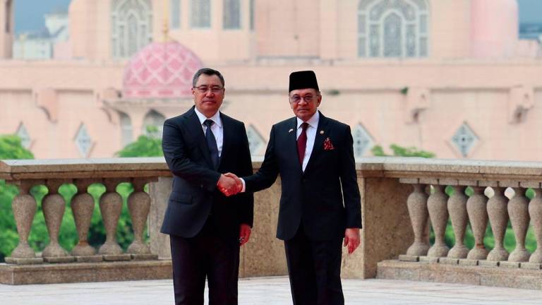 Prime Minister Datuk Seri Anwar Ibrahim (right) shakes hand with President of the Kyrgyz Republic Sadyr Zhaparov during an official welcoming ceremony at the Perdana Putra Complex today. - BERNAMAPIX