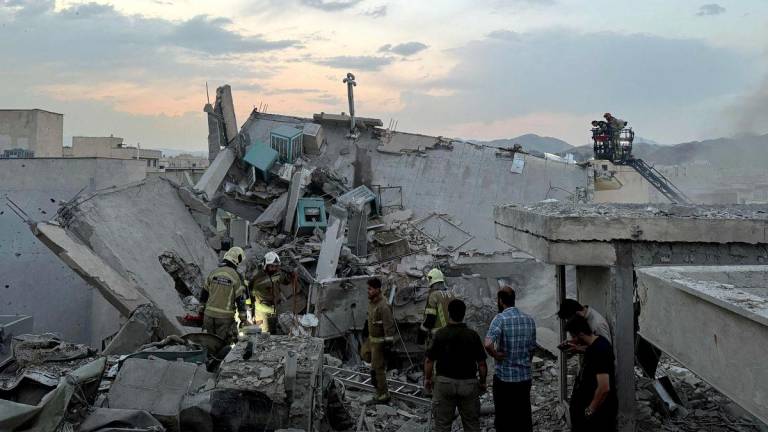 People and first-responders gather atop a building a that was hit by an Israeli strike in Tehran on June 13, 2025. - AFPPIX