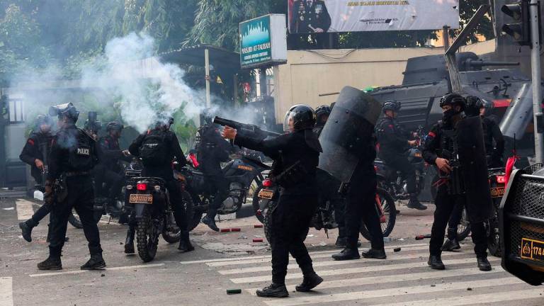 Riot police fire tear gas toward demonstrators during a clash outside Jakarta Mobile Brigade (Brimob) headquarters, after a motorcycle taxi driver died after being struck and run over by a police tactical vehicle during Thursday's protest on a number of issues including parliamentarians' allowances, education funding and the government's school meals programme, in Jakarta, Indonesia, August 29, 2025. - REUTERSPIX
