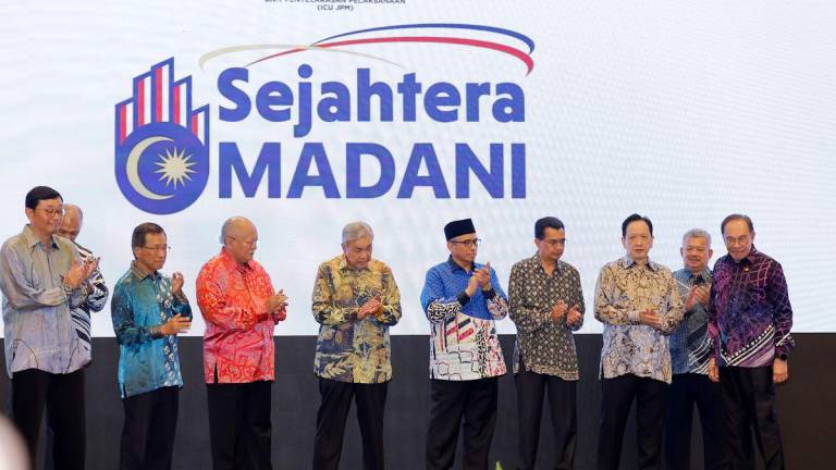 Anwar, Ahmad Zahid and Shamsul Azri (with songkok) with Tan (left) and other contributors during the launching ceremony at Kompleks Seri Perdana in Putrajaya yesterday. – BERNAMAPIC