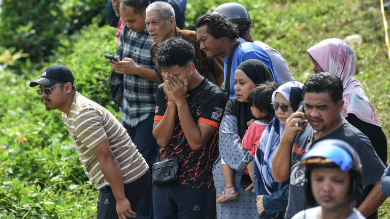 Sebahagian ahli keluarga dan kenalan tidak dapat menahan kesedihan selepas melihat enam mayat yang ditemukan dalam sebuah kereta di dalam Sungai Korok, dekat Jitra hari ini. - BERNAMA