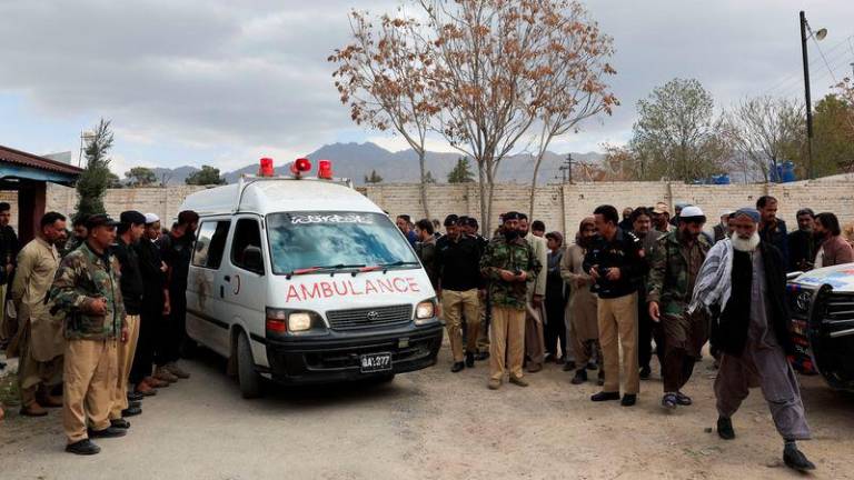 People gather next to an ambulance carrying the bodies of people, who were killed after a train was attacked by separatist militants in Bolan, during the funeral in Quetta, Pakistan, March 13, 2025. - REUTERSPIX