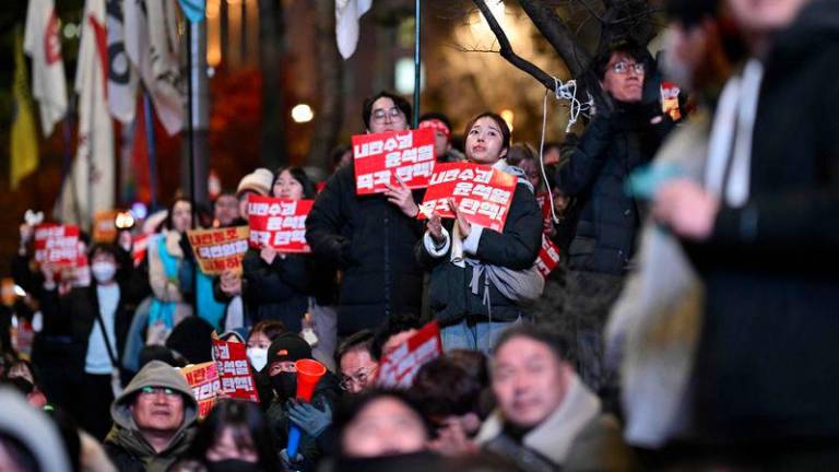 Demonstrators hold placards that read “impeach insurrection mastermind Yoon immediately!” during a protest calling for the ouster of South Korea President Yoon Suk Yeol on the grounds of the National Assembly in Seoul on December 9, 2024 - AFPpix