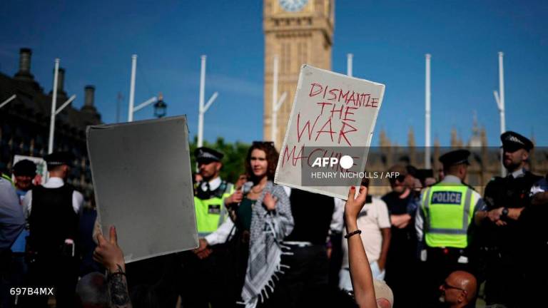 Protesters hold placards at a “Lift The Ban” demonstration in support of the proscribed group Palestine Action, calling for the recently imposed ban to be lifted, in Parliament Square, central London, on August 9, 2025. (Photo by HENRY NICHOLLS / AFP)