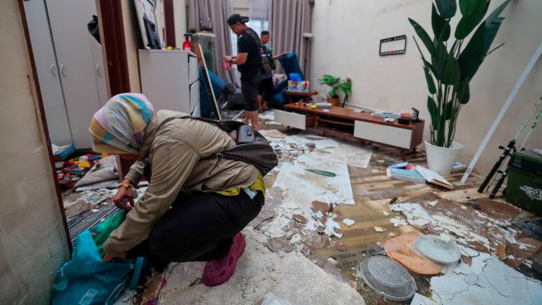 Mangsa Fazeela Yaccob bersama ahli keluarganya mengalihkan barangan yang rosak selepas bahagian bumbung rumahnya diterbangkan angin selepas kejadian ribut di PPR Seri Cempaka - fotoBERNAMA