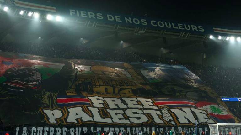 Paris' supporters hold a tifo reading Free Palestine ahead of the UEFA Champions League, League phase - Matchday 4, football match between Paris Saint-Germain (PSG) and Atletico Madrid, at the Parc des Princes stadium in Paris on November 6, 2024. - AFPPIX