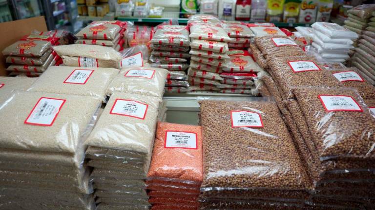 Bags of dal, lentils, chana, and other groceries imported from India are displayed for sale at Farm Fresh grocery as small businesses face tariffs, rising costs, and supply chain uncertainties in the Little India neighborhood of Artesia, California on August 7, 2025. - AFPPIX