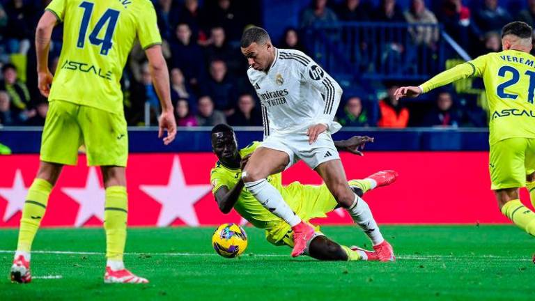 Real Madrid's French forward #09 Kylian Mbappe (C) runs past Villarreal's Senegalese midfielder #18 Pape Gueye during the Spanish League football match between Villarreal CF and Real Madrid CF at La Ceramica Stadium in Vila-real on March 15, 2025. - AFPPIX