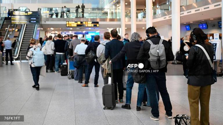 Passengers stand in a queue to get new tickets at the service point of the Copenhagen Airport in Copenhagen, Denmark, on September 23, 2025. (Photo by Sergei GAPON / AFP)