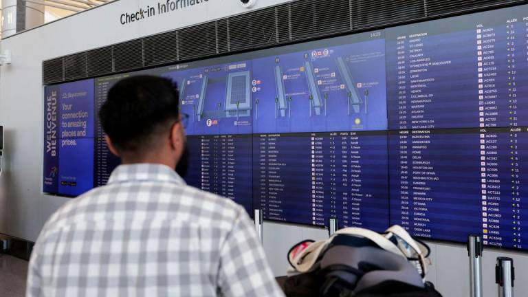 A stranded passenger looks at check-in information board as Air Canada flight attendants protest amid a standoff with a government board that said the stoppage was unlawful, at Toronto Pearson International Airport in Mississauga, Ontario, Canada August 18, 2025. - REUTERSPIX