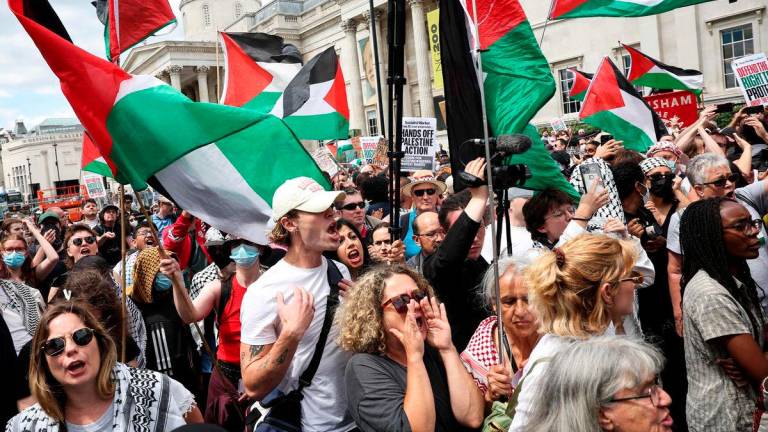 Protestors wave Palestinian flags in front of the National Gallery in Trafalgar Square as the rally for a protest in support of pro-Palestinian group Palestine Action, in central London, on June 23, 2025. (Photo by HENRY NICHOLLS / AFP)
