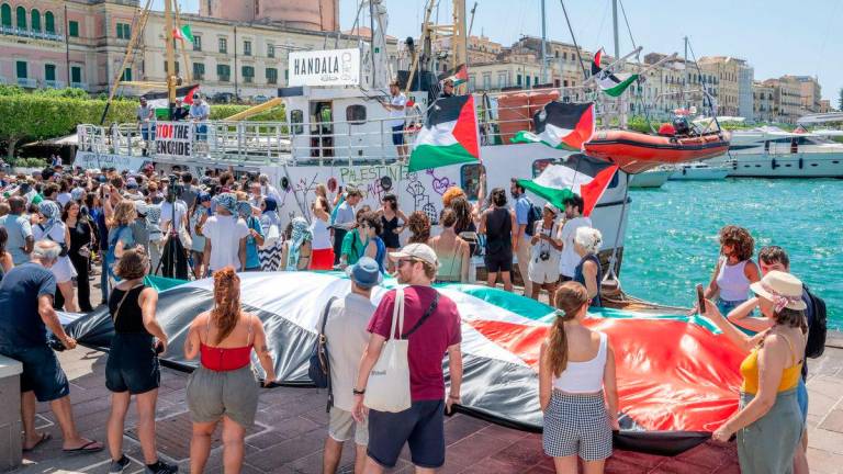 People gather around the Freedom Flotilla ship “Handala” ahead of the boat’s departure for Gaza at a port in Syracuse, Sicily, southern Italy, on July 13, 2025. (Photo by Giovanni ISOLINO / AFP)