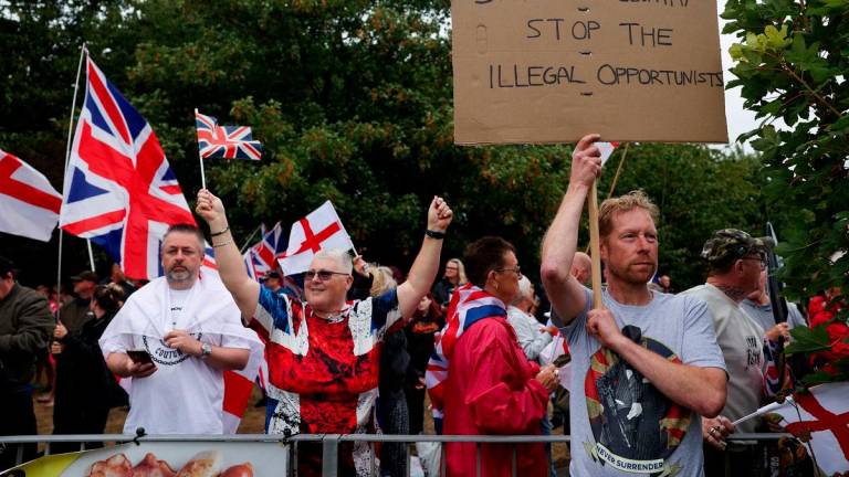 People gather near the IHG Holiday Inn in Woolston as they protest over asylum seekers being housed in the hotel, in Warrington, Britain, August 30, 2025. REUTERS/Temilade Adelaja
