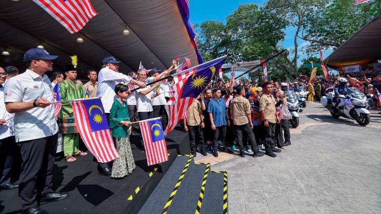 Prime Minister Datuk Seri Anwar Ibrahim flagging off participants during the departure of the Jalur Gemilang flag-flying convoy after the National Month 2025 Launching Ceremony at Dataran Tanjung Emas today. - Bernama pic