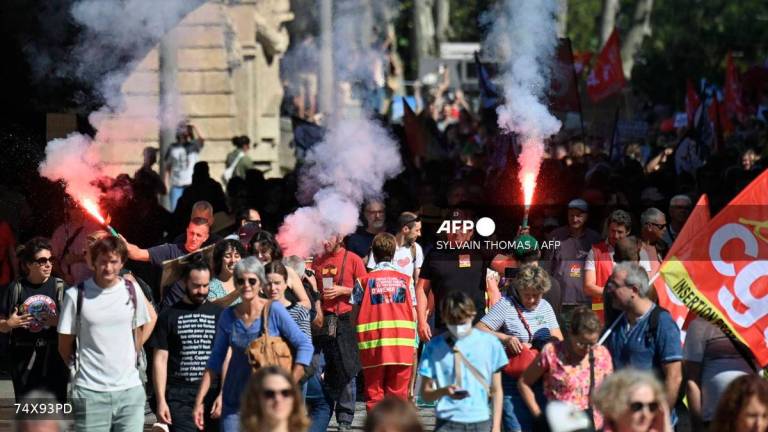 Demonstrators light flares as they protest in Montpellier, southern France, on September 18, 2025, during a day of nationwide strikes and protests called by unions over France's national budget. - AFP