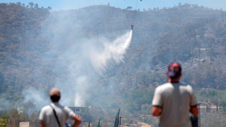A Turkish helicopter helps battle a forest fires in the coastal Syrian province of Latakia on July 5, 2025. (Photo by OMAR HAJ KADOUR / AFP)