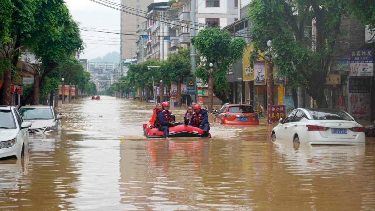 Rescuers help evacuate residents from a flooded street in Rongjiang, in China’s southwest Guizhou province on June 24, 2025. (Photo by AFP)
