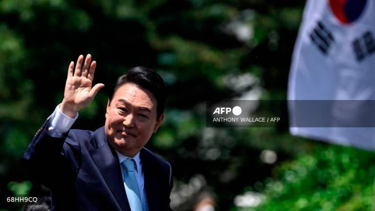 South Korea’s President Yoon Suk-yeol waves from his car after his inauguration ceremony at the National Assembly in Seoul on May 10, 2022. - AFP