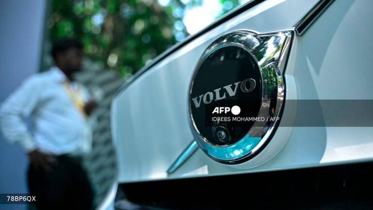 A visitor stands next to Volvo EC 40 electric car during the India Innovation Summit – Innoverge 2025 organised by the Confederation of Indian Industry (CII) in Bengaluru on October 10, 2025. - AFP