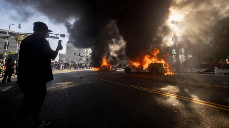 Federal agents clashed with angry crowds in a Los Angeles suburb as protests stretched into a second night Saturday, shooting flash-bang grenades and shutting part of a freeway amid raids on undocumented migrants, reports said.