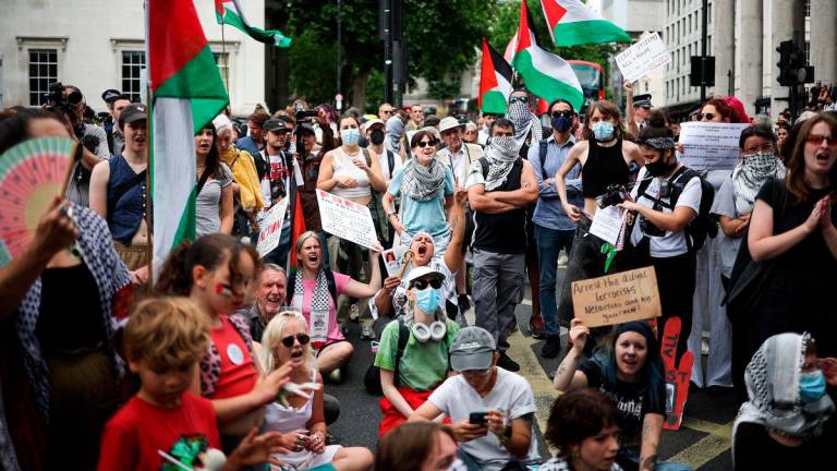 Protestors shout slogans and wave Palestinian flags as they rally in support of pro-Palestinian group Palestine Action after British government announced the group’s ban, in Trafalgar Square, in central London, on June 23, 2025. (Photo by HENRY NICHOLLS / AFP)