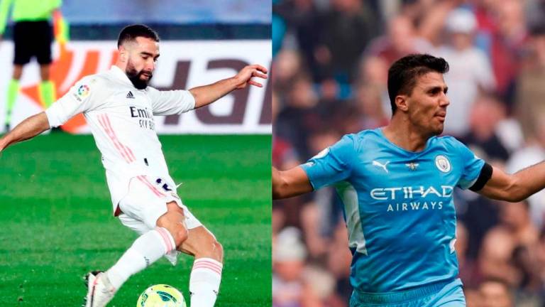 Real Madrid right back Dani Carvajal (left) and Manchester City midfielder Rodri (left). - REUTERS