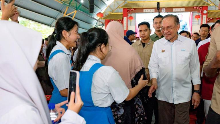 Perdana Menteri Datuk Seri Anwar Ibrahim beramah mesra bersama para pelajar pada program Majlis Sumbangan Kasih Madani sempena Deepavali 2025 di Sekolah Menengah Jenis Kebangsaan Poi Lam hari ini. - BERNAMA
