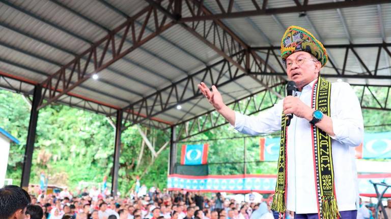 Perdana Menteri Datuk Seri Anwar Ibrahim berucap pada Program Rapat Umum dan Himpunan KEADILAN Sempena 27 Tahun Refomasi di Dewan Pisompuruan Kampung Kobuni Inanam hari ini. - BERNAMA