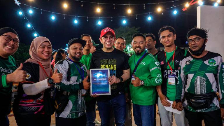 Human Resources Minister Steven Sim Chee Keong poses with gig workers during the Penang Rider Jalan Teruih Program at Healing Sampai Pagi last night (21 Sept). - BERNAMA