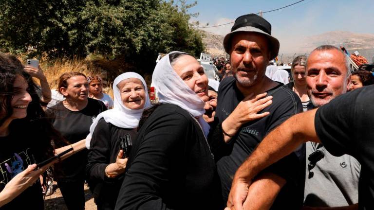 Shadi Abu Zaid (C), a Syrian Druze man, is received by members of the Druze community as he arrives in the Druze village of Majdal Shams in the Israeli-annexed Golan Heights on July 16, 2025. (Photo by Jalaa MAREY / AFP)