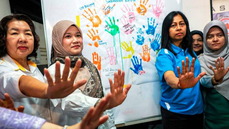 Menteri Pendidikan Fadhlina Sidek (dua, kiri) bergambar dengan poster anti buli pada Kempen Jelajah Anti Buli di Yayasan Aman hari ini. - BERNAMA