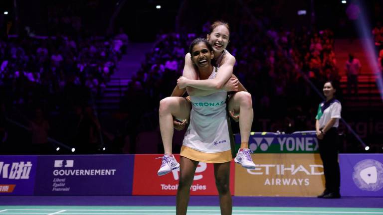 Malaysia's Pearly Tan and Thinaah Muralitharan at BWF World Championships, celebrating after winning their women's doubles semifinal match against Japan's Chiharu Shida and Nami Matsuyama. - REUTERS