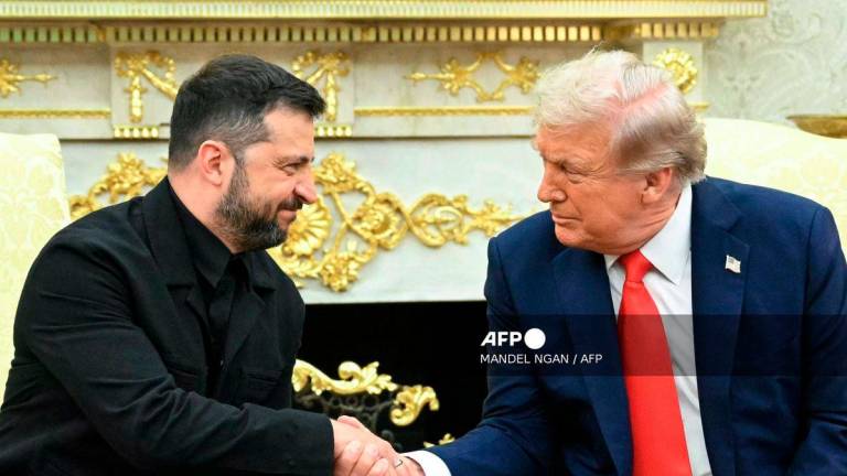 Ukrainian President Volodymyr Zelensky and US President Donald Trump shake hands during a meeting in the Oval Office of the White House in Washington, DC, on August 18, 2025. - AFP