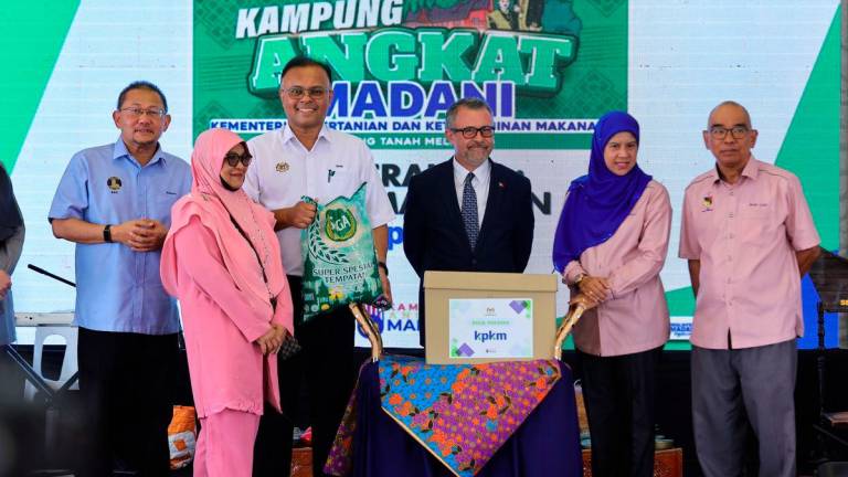 Ketua Setiausaha Kementerian Pertanian dan Keterjaminan Makanan (KPKM) Datuk Seri Isham Ishak menyampaikan sumbangan Bakul Makanan ketika Majlis Peluncuran Kampung Angkat MADANI KPKM di Sekolah Kebangsaan Tanah Melintang hari ini. - BERNAMA