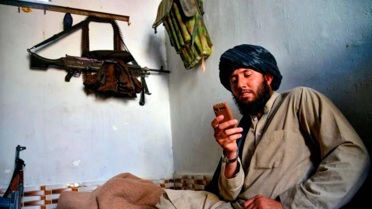 A Taliban security personnel uses a non-smartphone in Kandahar on June 17, 2025 (Sanaullah SEIAM) (Sanaullah SEIAM/AFP/AFP)