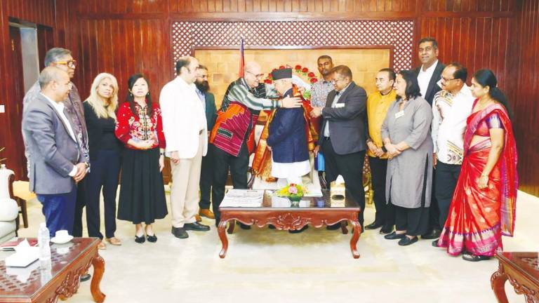 Pardip placing a ceremonial shawl on Oli on behalf of the visiting delegation.