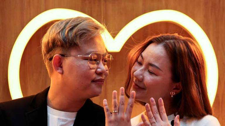 An LBGTQ+ couple, Pawan Iamwet, 35, and Kamonchanok Chumruan, 38, pose for a picture as they wait to receive official marriage certificates - REUTERSpix