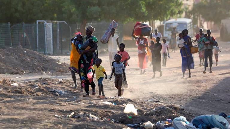 People flee amid fighting between the army and paramilitaries in Khartoum, Sudan, on April 19, 2023. The U.N. estimates that more than 4.8 million people have been displaced internally in Sudan and 1.2 million have fled to neighboring countries since April. | AFP/Getty Images