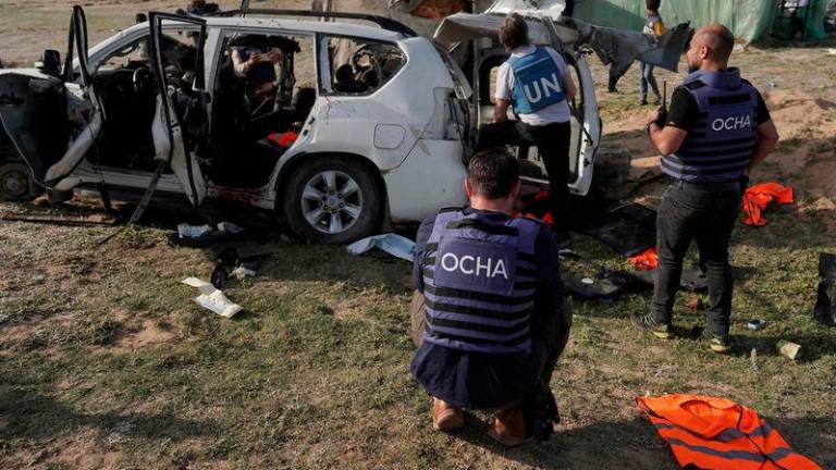 United Nations staff members inspect the carcass of a car used by US-based aid group World Central Kitchen, that was hit by an Israeli strike the previous day in Deir al-Balah in the central Gaza Strip - AFPpix
