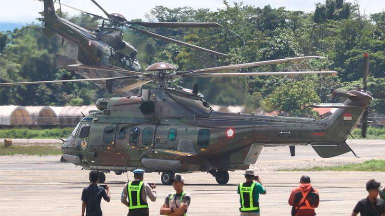 Indonesian Air Force helicopters take off as they evacuate the body of a New Zealand helicopter pilot at Mozes Kilangin Airport in Timika - AFPpix