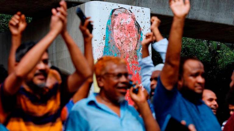 A mural of Prime Minister Sheik Hasina is seen vandalised by protesters as people celebrate her resignation in Dhaka - REUTERSpix