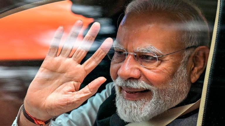 India’s Prime Minister Narendra Modi waves upon his arrival to inaugurate the new Vande Bharat passenger train and Yellow Line of the Namma Metro in Bengaluru on August 10, 2025. - AFP