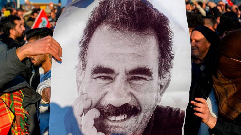 Supporters display a poster featuring an image of jailed leader of the Kurdistan Workers’ Party (PKK) Abdullah Ocalan after he called on the Kurdistan Workers’ Party (PKK) to disarm and dissolve itself in Diyarbakir, south-eastern Turkey on February 27, 2025. (Photo by Yasin AKGUL / AFP)